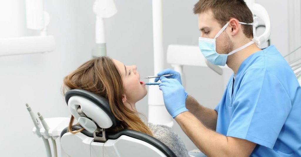 a dentist examining a patient’s gums for signs of periodontal disease using dental instruments in a clinical setting