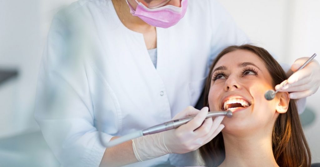 a dentist examining a patient’s teeth during a dental check-up to assess tooth decay and dental health.