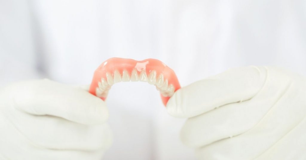 a close-up of a removable lower denture showing potential gaps that may require adjustment or dental adhesive for a better fit